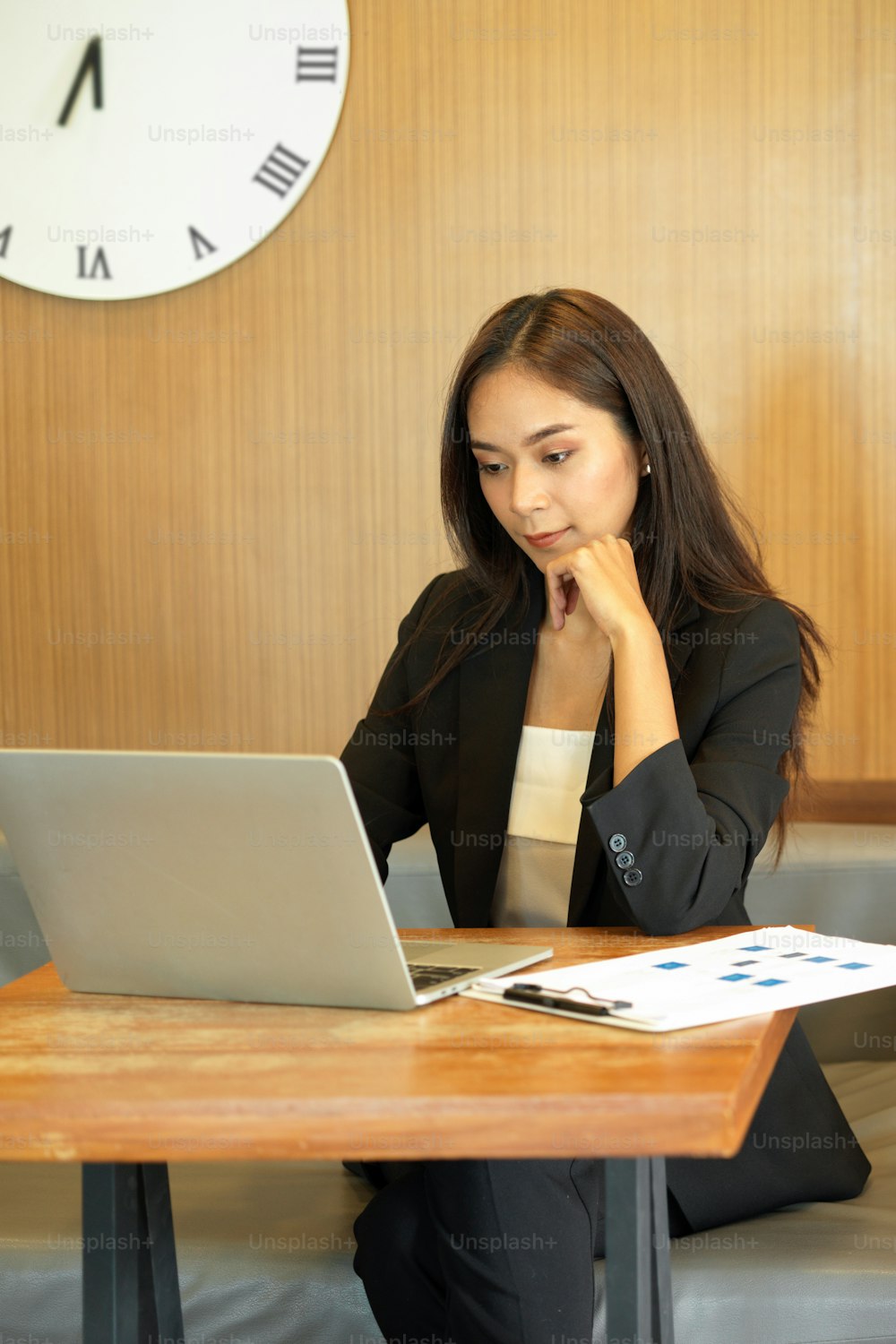 Femme d’affaires élégante travaillant et pensant à des idées d’affaires sur un ordinateur portable. Assis dans un espace de co-working moderne