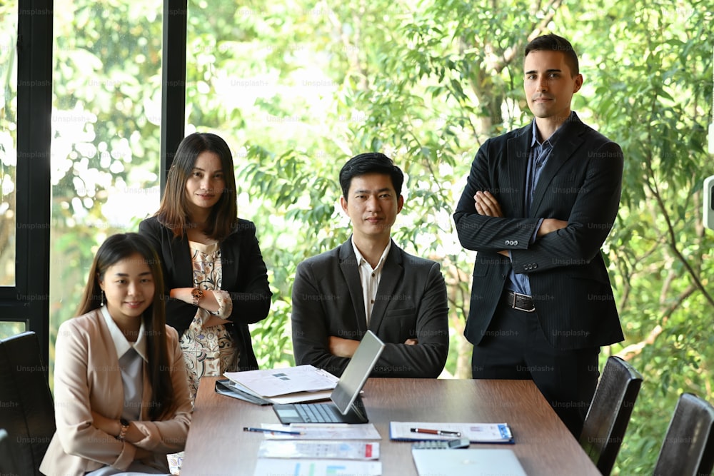 Group of successful business people at modern office smiling and looking at camera.