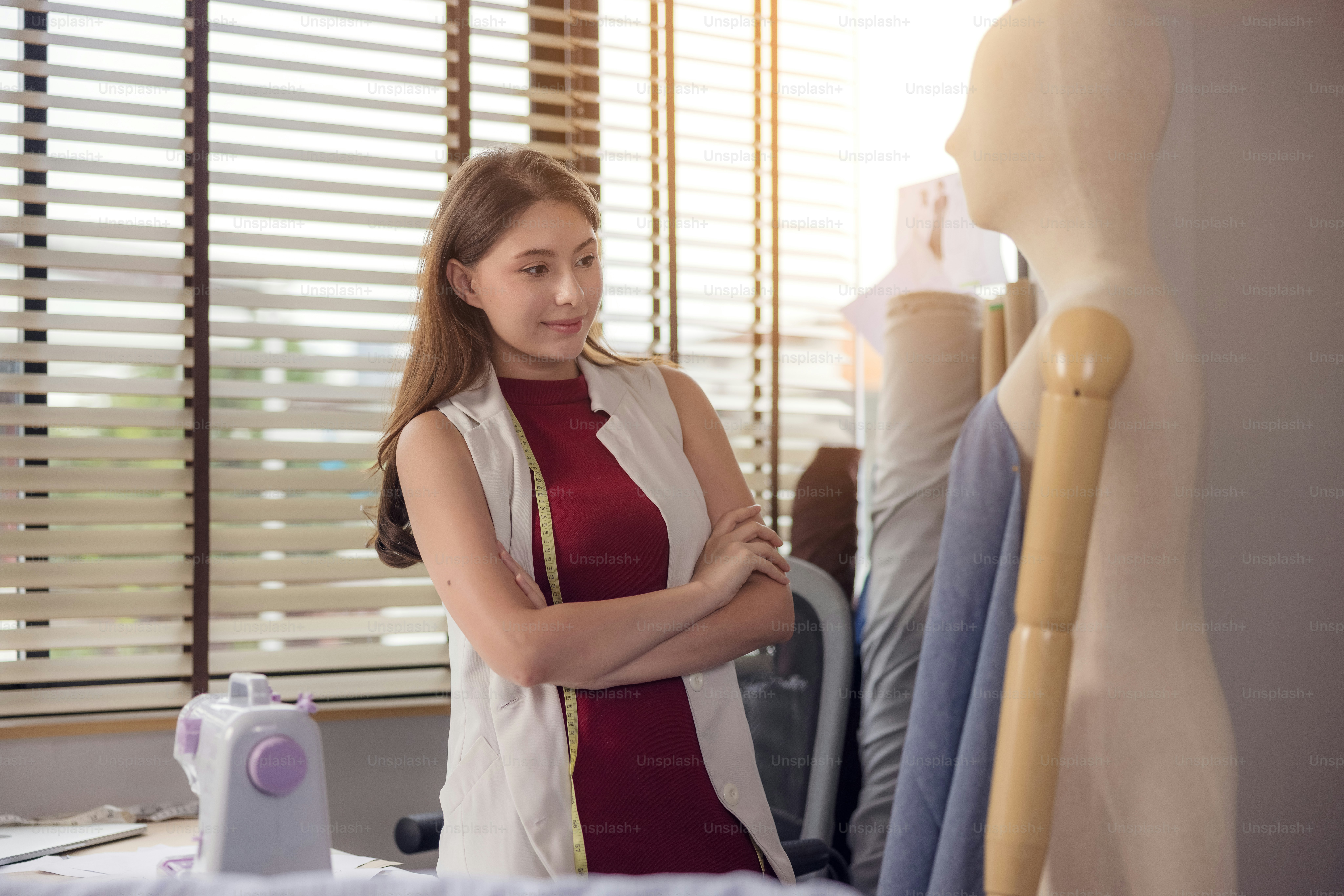 A model is used by a fashion designer to try on new designer garments ...