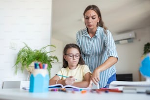 Madre e hija estresadas frustradas por el fracaso de la tarea, el concepto de problemas escolares. Niña triste alejada de su madre, no quiere hacer tareas aburridas