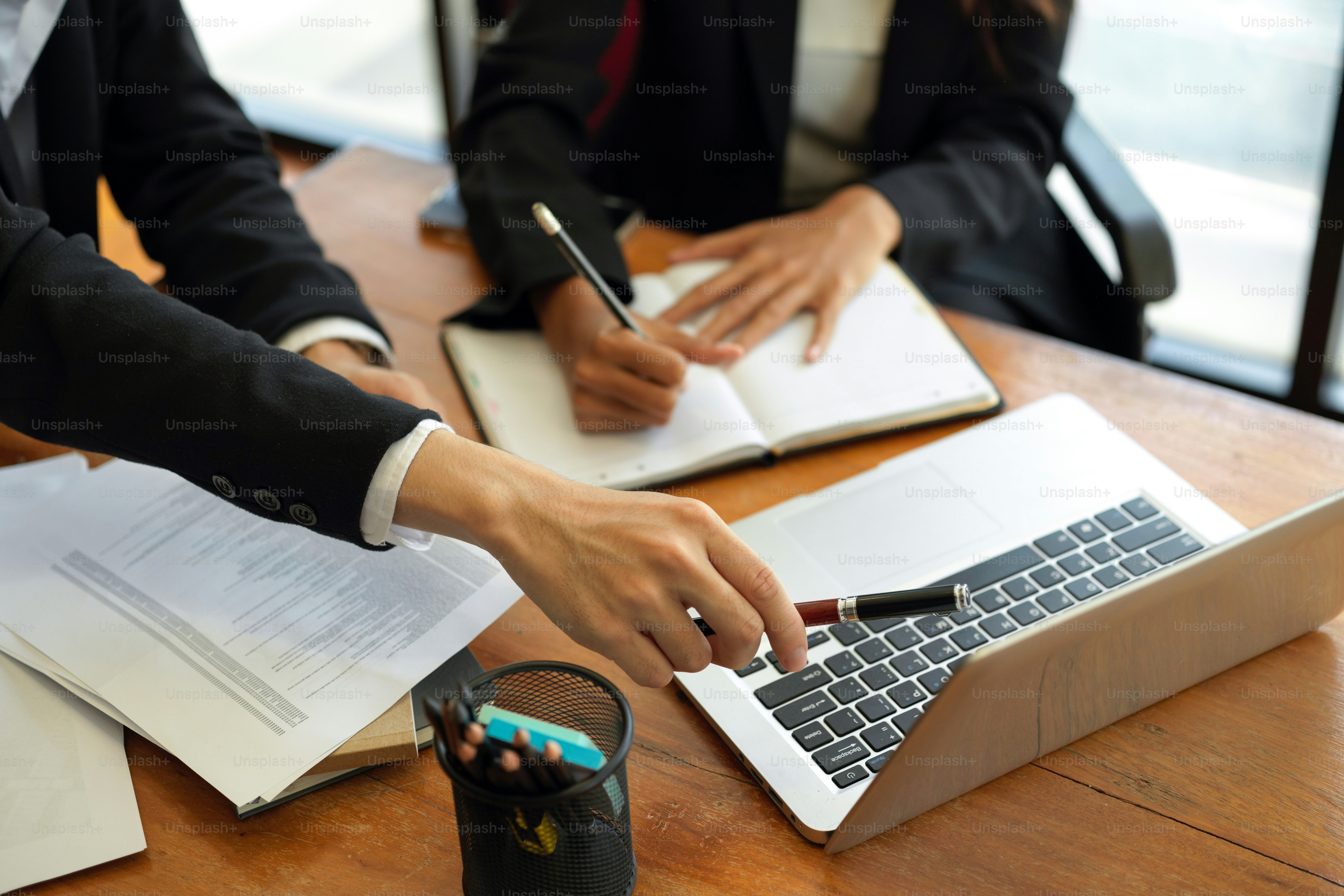 Cropped shot, Colleagues discussing work process. sitting at table with notebooks and laptop. Business partners brainstorming ideas at meeting