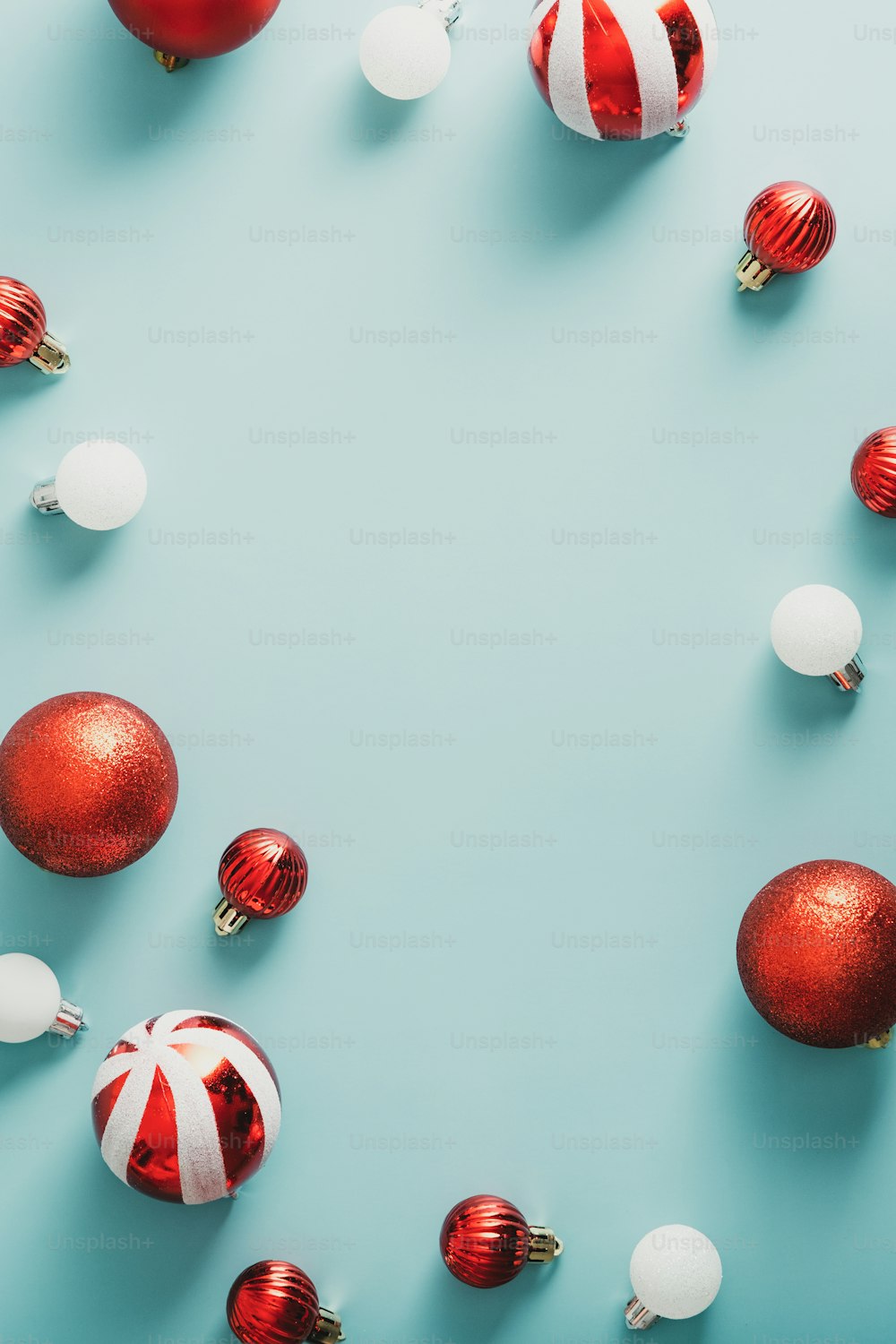 メリークリスマスと新年あけましておめでとうございますポスターデザイン。青い背景にビンテージの縞模様のボールで作られたフレーム。フラットレイ、上面図、コピースペース。