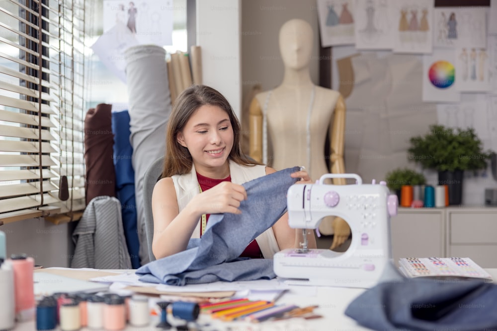 Ein Modell wird von einem Modedesigner verwendet, um neue Designerkleidungsstücke anzuprobieren. Bei der Arbeit entwirft eine Unternehmerin in ihrem Stoffgeschäft neue Kleidung für einen Modedesigner.