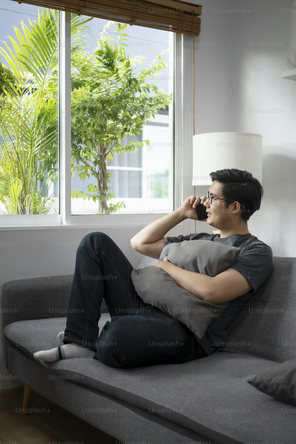 Happy casual man sitting on sofa and talking on mobile phone.