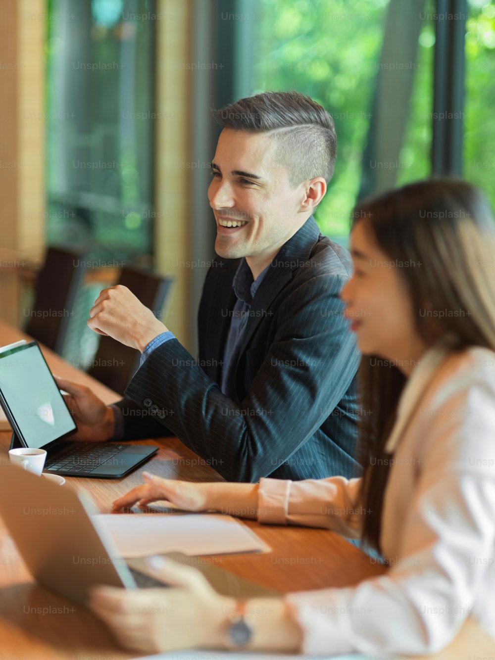 Cheerful businessman and businesswoman are meeting in conference room