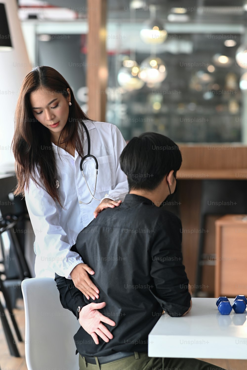 Doctor examine young man with low back pain.