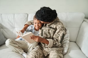 息子の元に帰るミレニアル世代の女性兵士。お母さんと抱き合って一緒に本を読む男の子。家族の再会のコンセプト