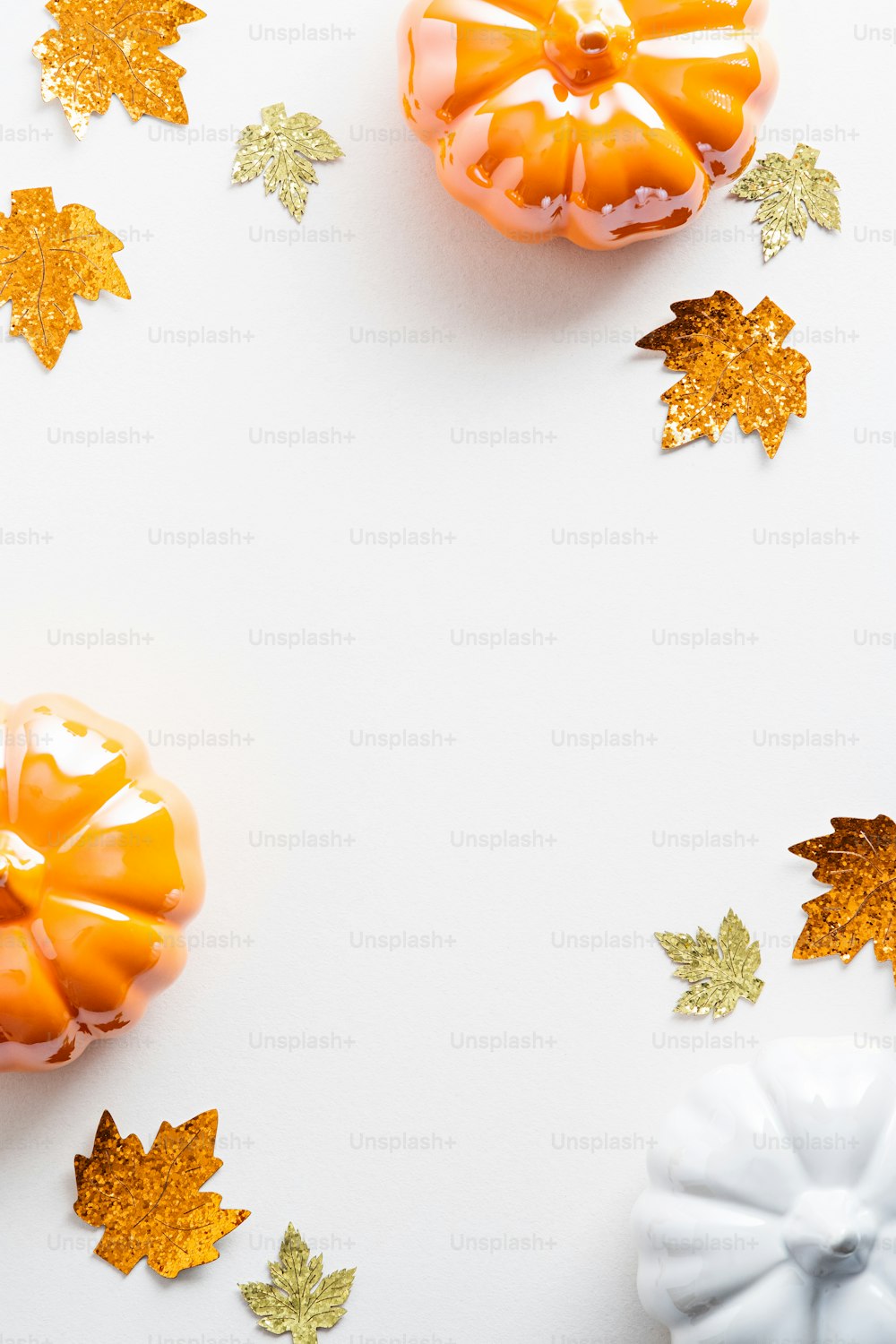Autumn flat lay composition with pumpkins and maple leaves on a white background. Autumn, fall, Thanksgiving concept.