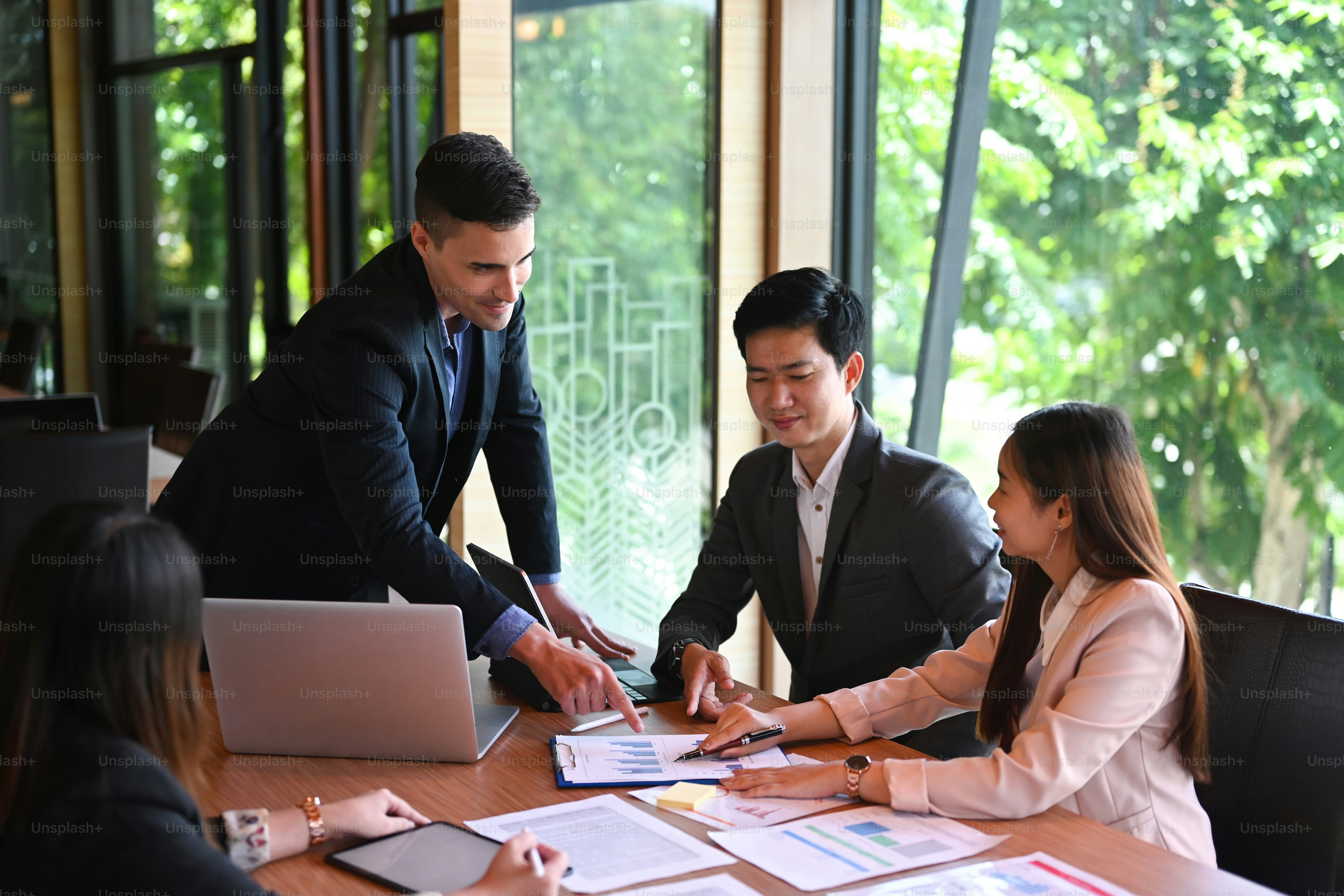Group of business people sitting around the office desk and discussing the project together