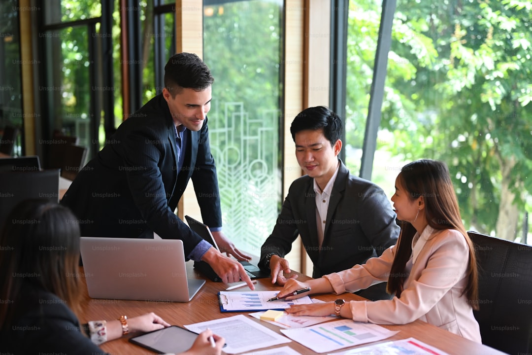 Group of business people sitting around the office desk and discussing the project together.