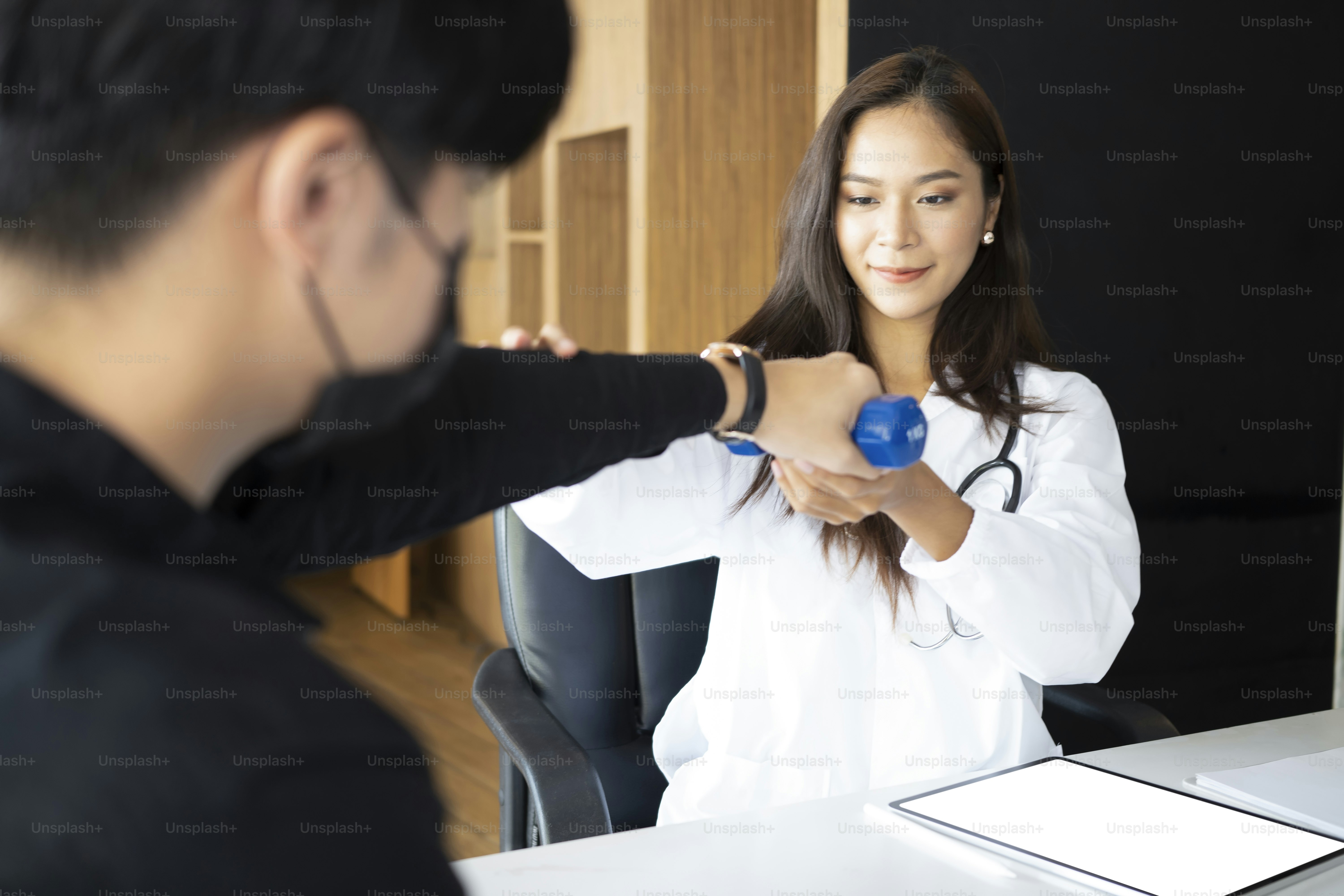 Beautiful woman physiotherapist doing therapeutic exercises for her patient.