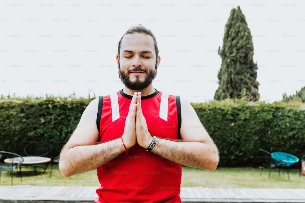 Portrait of latin guy meditating calmly with closed eyes in outdoor yoga class in Latin America