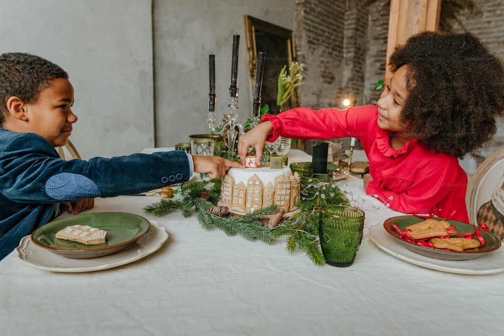 Sœur et frère décorant un gâteau en pain d’épice à la maison. Concept de loisirs familiaux pour la période de Noël. Idée de bonbons de bonne année faits à la main bricolage.