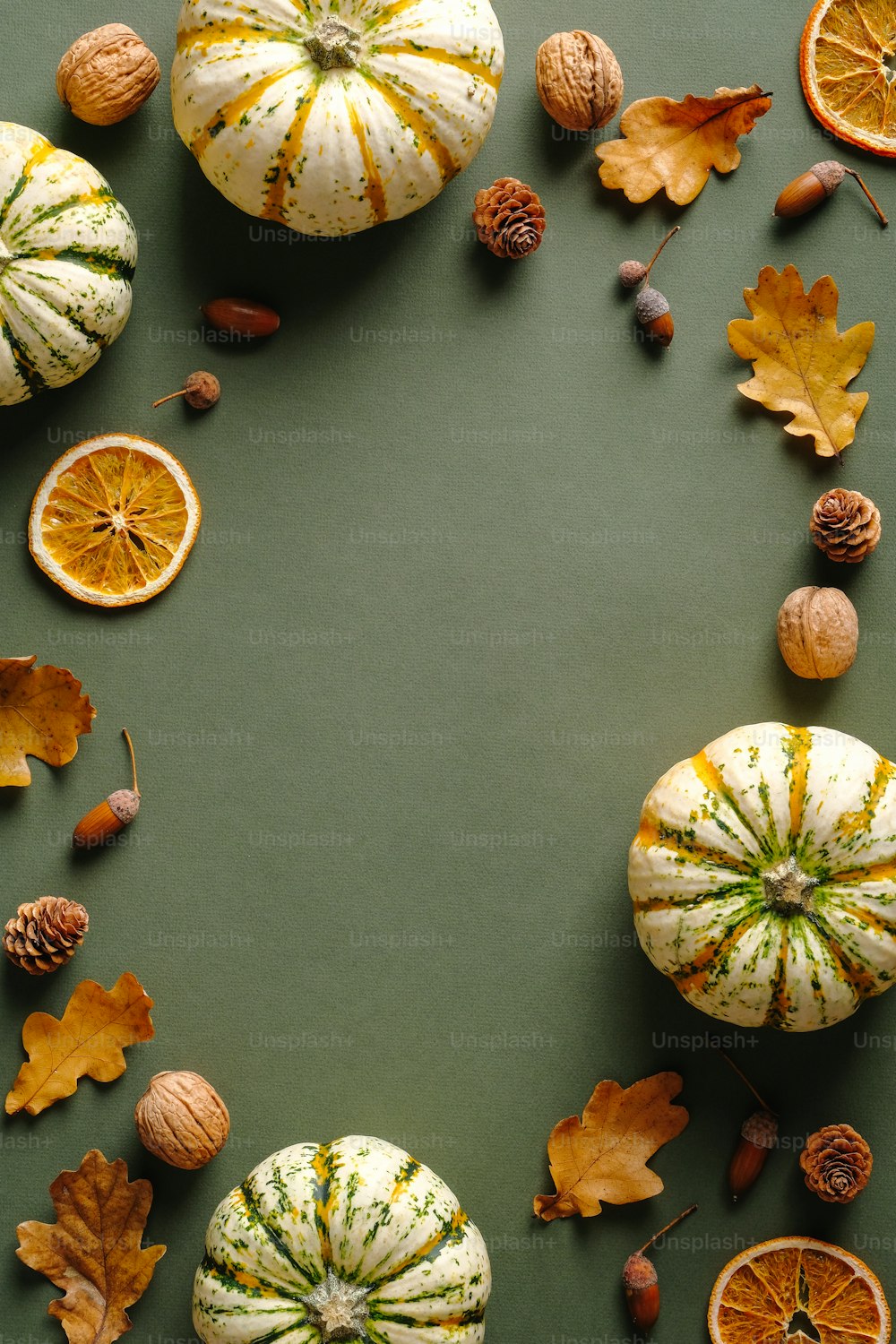 Feliz conceito de Ação de Graças. Composição de outono com abóboras maduras, folhas caídas, laranjas secas, nozes na mesa verde rústica. Flat lay, vista superior, espaço de cópia.