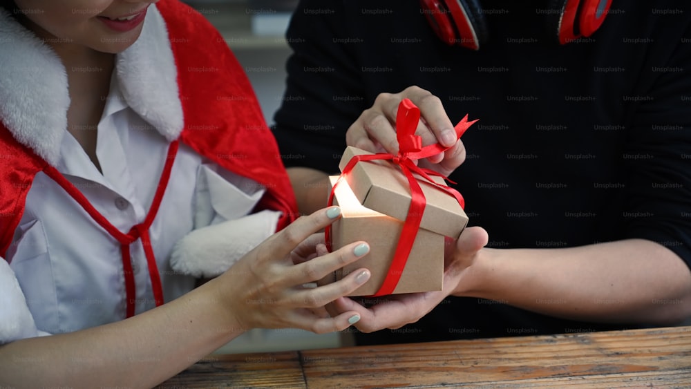 Cropped shot sweet couple opening Christmas gifts.