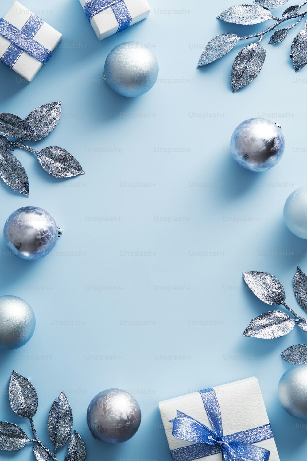 青い背景にモダンな装飾、ボール、ギフトボックスのクリスマスフレーム。クリスマスポスターデザイン、新年会招待状のモックアップ。