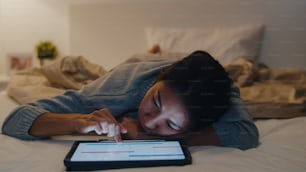 Freelance Ásia mulheres casuais usar laptop trabalho duro na cama no quarto em casa à noite. Trabalho em casa, trabalho remoto, autoisolamento, distanciamento social, quarentena para prevenção do coronavírus.