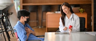 Female doctor diagnose male patient in examination room. Physician consults male patient giving an medical advice