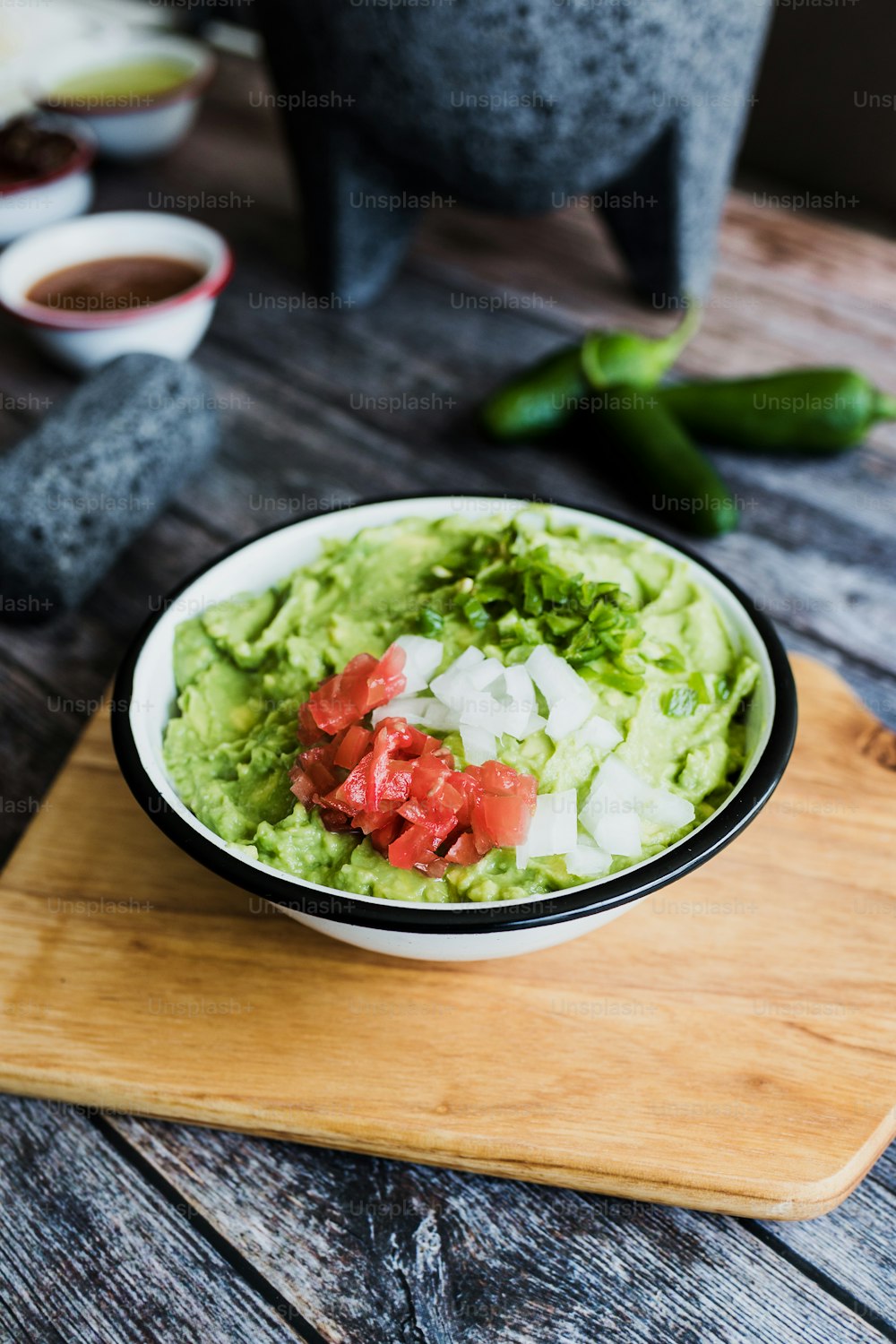 Tazón de guacamole junto a ingredientes frescos en una mesa de madera en México