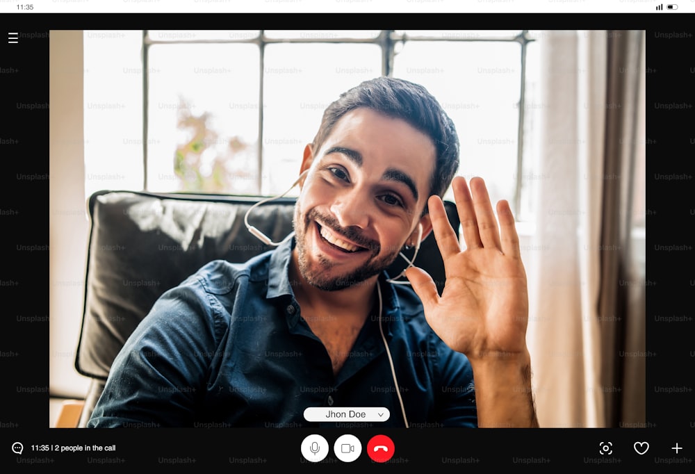 Young businessman saying hello to someone on a video call while working remotely from home. New normal lifestyle. Business concept.