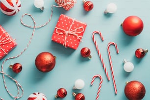 빈트게 크리스마스 플랫은 청록색 배경에 빨간색 선물 상자, 공, 사탕 지팡이가 있는 구성입니다. 플랫 레이, 평면도.