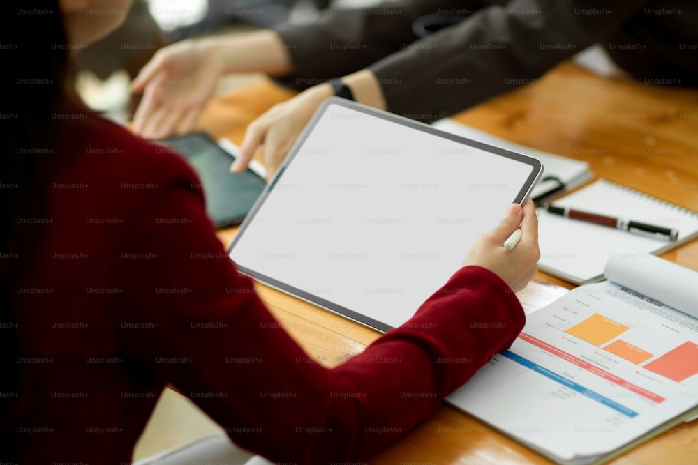 Recortado, chefe do sexo feminino de negócios usando tablet digital em reunião de negócios, tablet modelo de tela em branco para montagem do seu gráfico.
