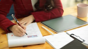 Imagen de primer plano de mujeres de negocios inteligentes que trabajan en la oficina, escribiendo y revisando documentos de datos comerciales