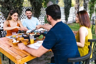 Group of Young latin Friends Meeting For beer, michelada Drinks And mexican Food Making A Toast In Restaurant terrace in Mexico Latin America