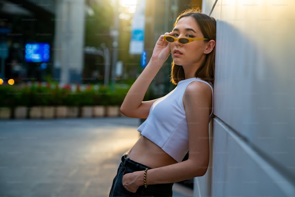 Portrait of Young beautiful Asian woman in casual clothing walking down city street and shopping at downtown district. Pretty girl enjoy urban outdoor weekend activity lifestyle and city life.