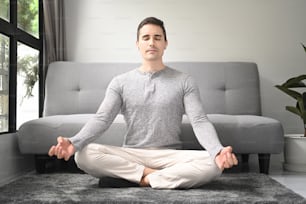 Young man practicing fitness in living room.