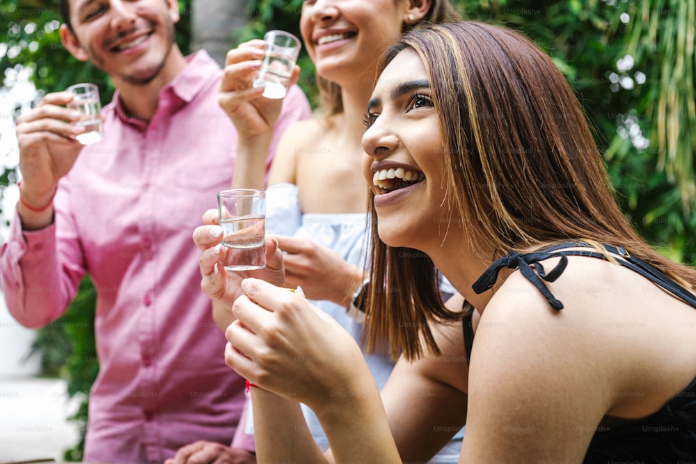 Tequila Shot, Treffen junger lateinamerikanischer Freunde Für Tequila-Shot oder Mezcal-Getränke machen Ein Toast In Restaurant Terrasse in Mexiko Lateinamerika
