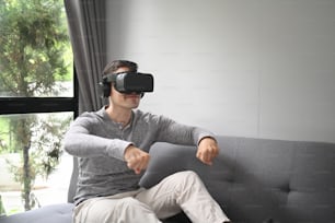 Young man laying video games in virtual reality glasses.