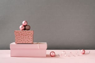 Caixas com presentes de Natal e enfeites no fundo rosa pastel com espaço de cópia