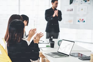 Businesswoman in analyze stock market data using laptop computer proficiently at the office while attending a group meeting with business team .