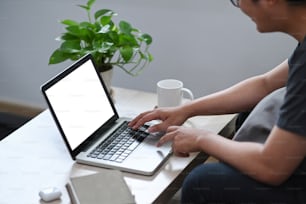 Jeune homme surfant sur Internet avec un ordinateur portable à la maison.