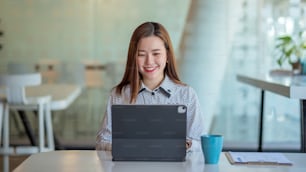 Young asian business woman beautiful charming smiling and using digital tablet in office.