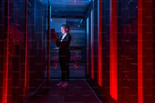Giovane ingegnere IT femminile con il problema di risoluzione del laptop tra i rack del server nel data center