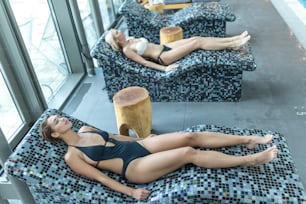 Mujeres jóvenes relajándose en sauna de vapor. mujeres con cuerpo delgado y piel sana descansando y tomando procedimientos de spa en el hammam o baño turco