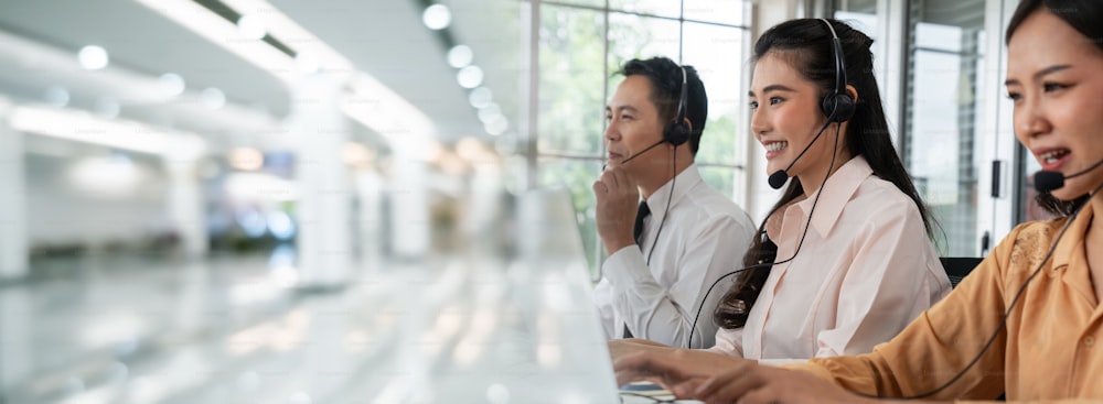 Business-Team trägt Headset arbeitet aktiv im Büro. Call-Center, Telemarketing, Kundendienstmitarbeiter bieten Service auf Telefon-Videokonferenz-Anruf.