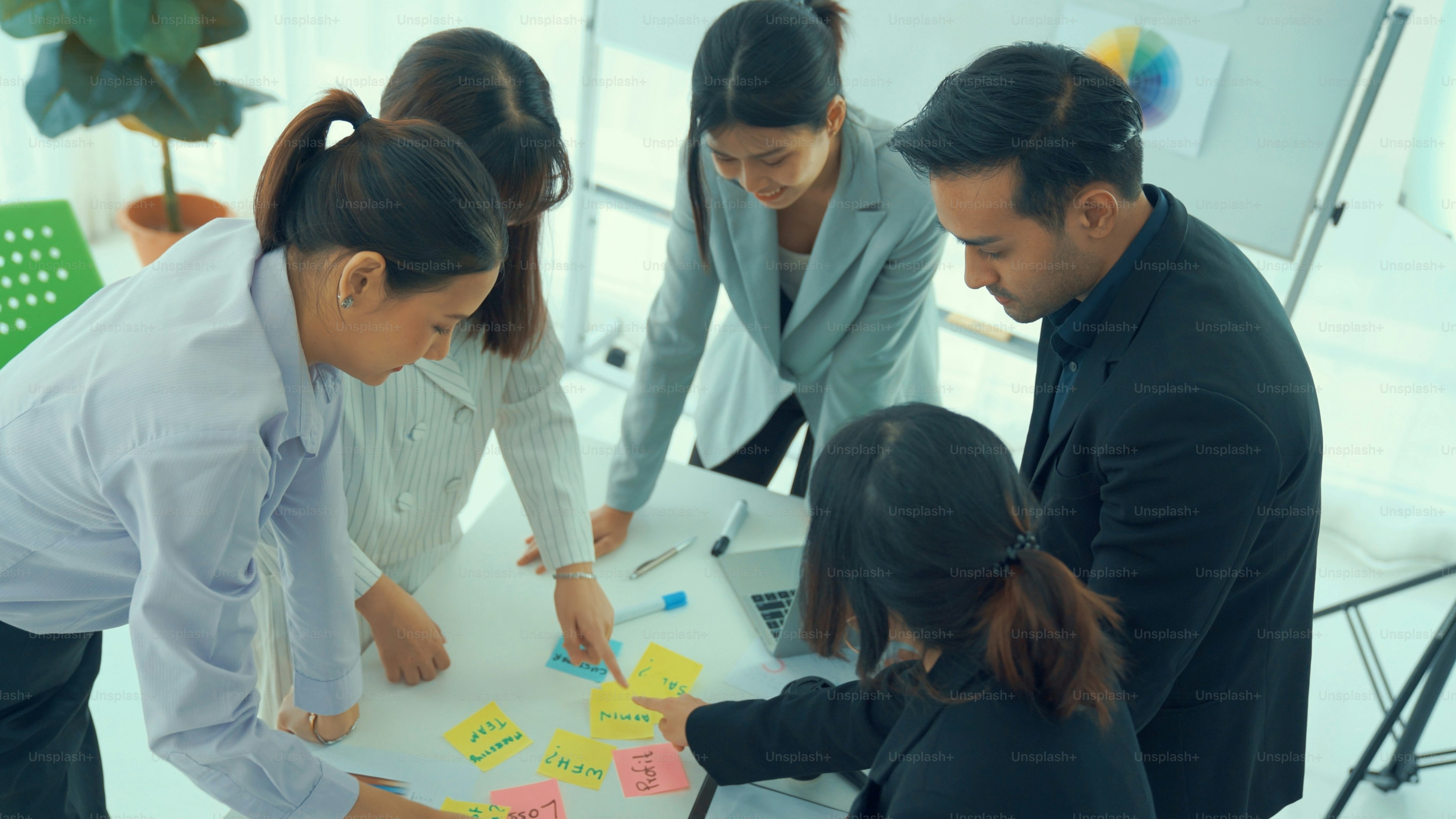 Business people proficiently discuss work project on meeting table . Corporate business team collaboration concept .