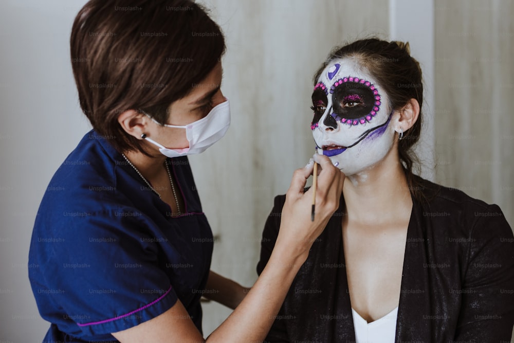멕시코 카트리나, 멕시코에서 죽은 자의 날 또는 할로윈을 위한 전통적인 해골을 만드는 젊은 라틴 여성 메이크업 아티스트
