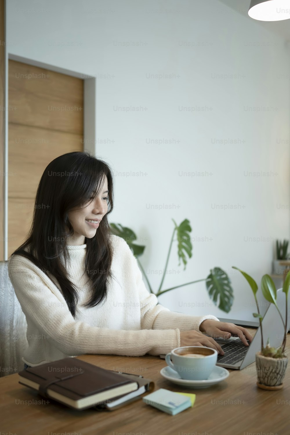 Smiling female small business entrepreneur working with laptop computer.