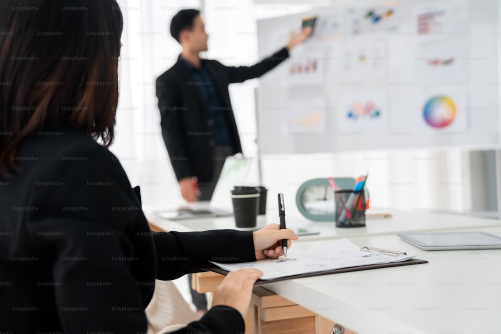 Empresária em reunião de negócios escrevendo papel com proficiência na sala de escritório. Colaboração da equipe de negócios corporativos