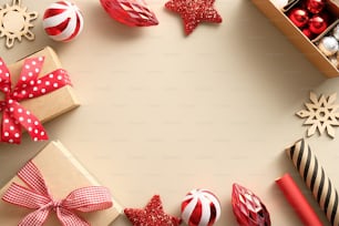 Vintage-Weihnachtshintergrund. Gestell aus Geschenken, Holzdekorationen, roten Kugeln, Geschenkpapier auf beigem Tisch. Retro Weihnachtspostkarte Vorlage