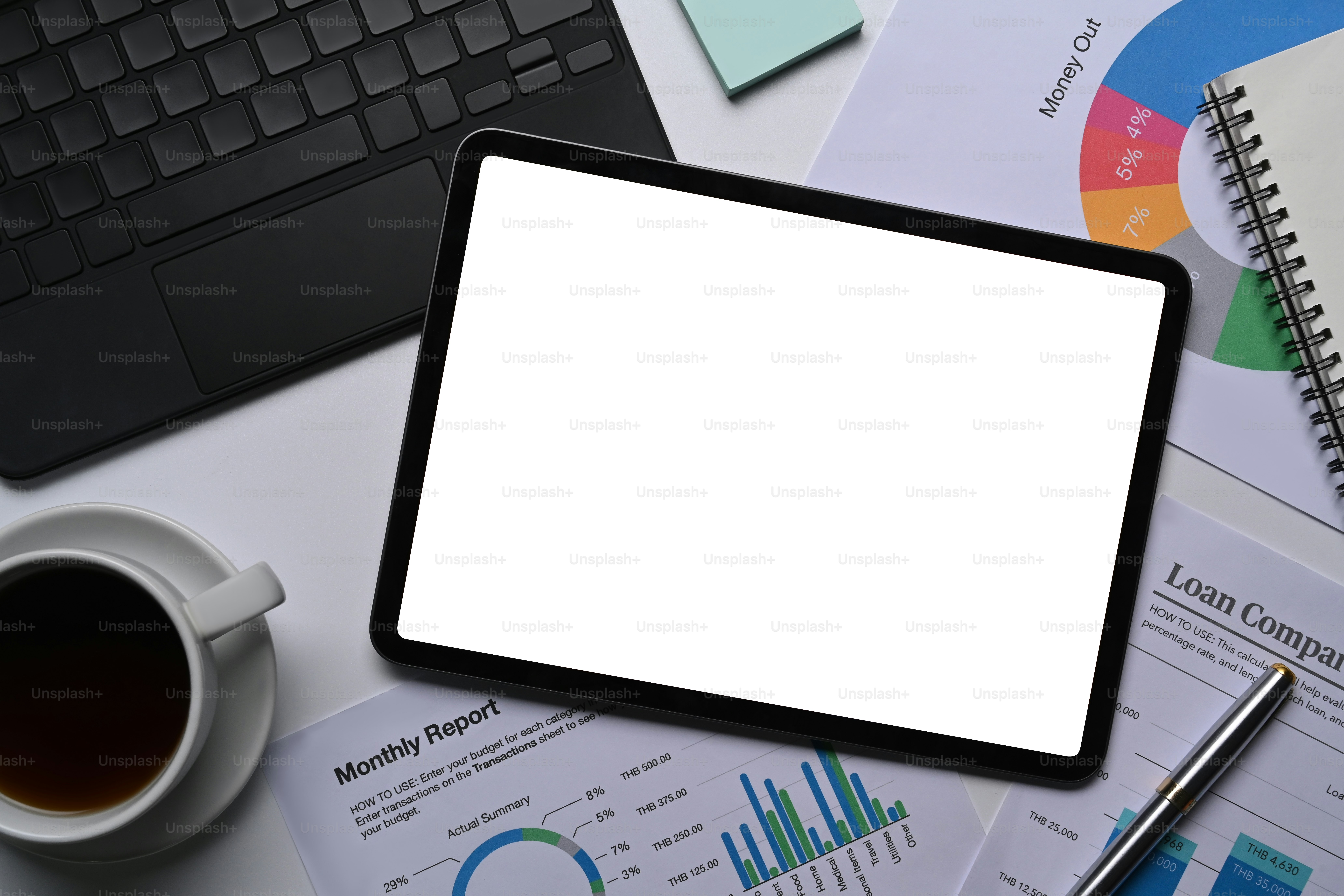 Above view mock up digital tablet, coffee cup and financial documents on white office desk.