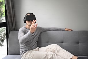 Jóvenes que usan auriculares de realidad virtual y juegan videojuegos o ven películas en casa.