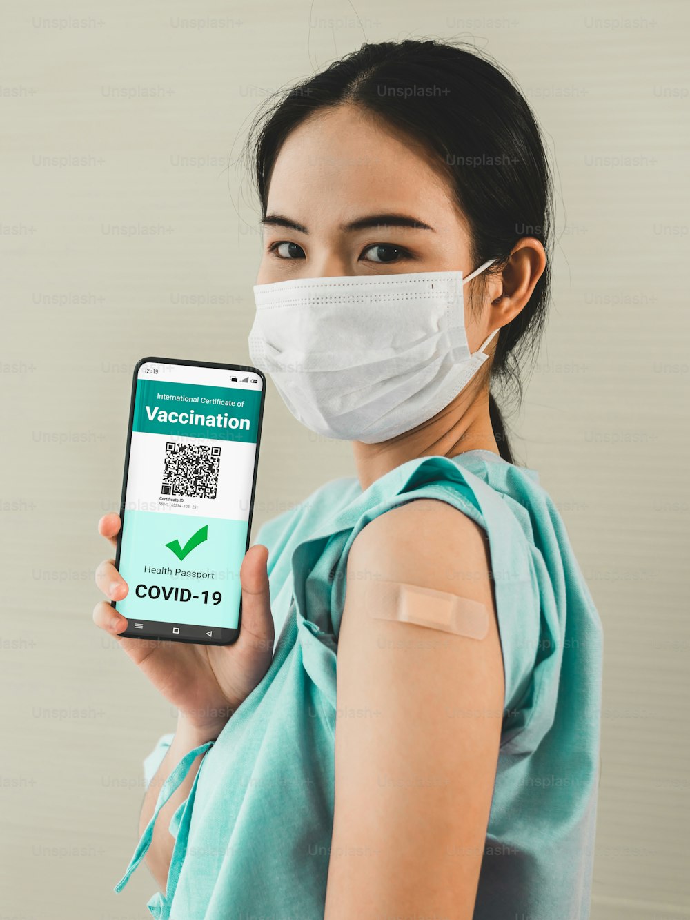 Junge Asiatin zeigt Impfpass auf Mobiltelefon, um die Reiseerlaubnis durch das digitale Dokument zu validieren
