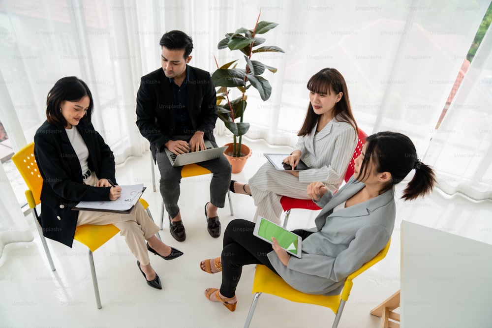 Business people proficiently discuss work project while sitting in circle . Corporate business team collaboration concept .