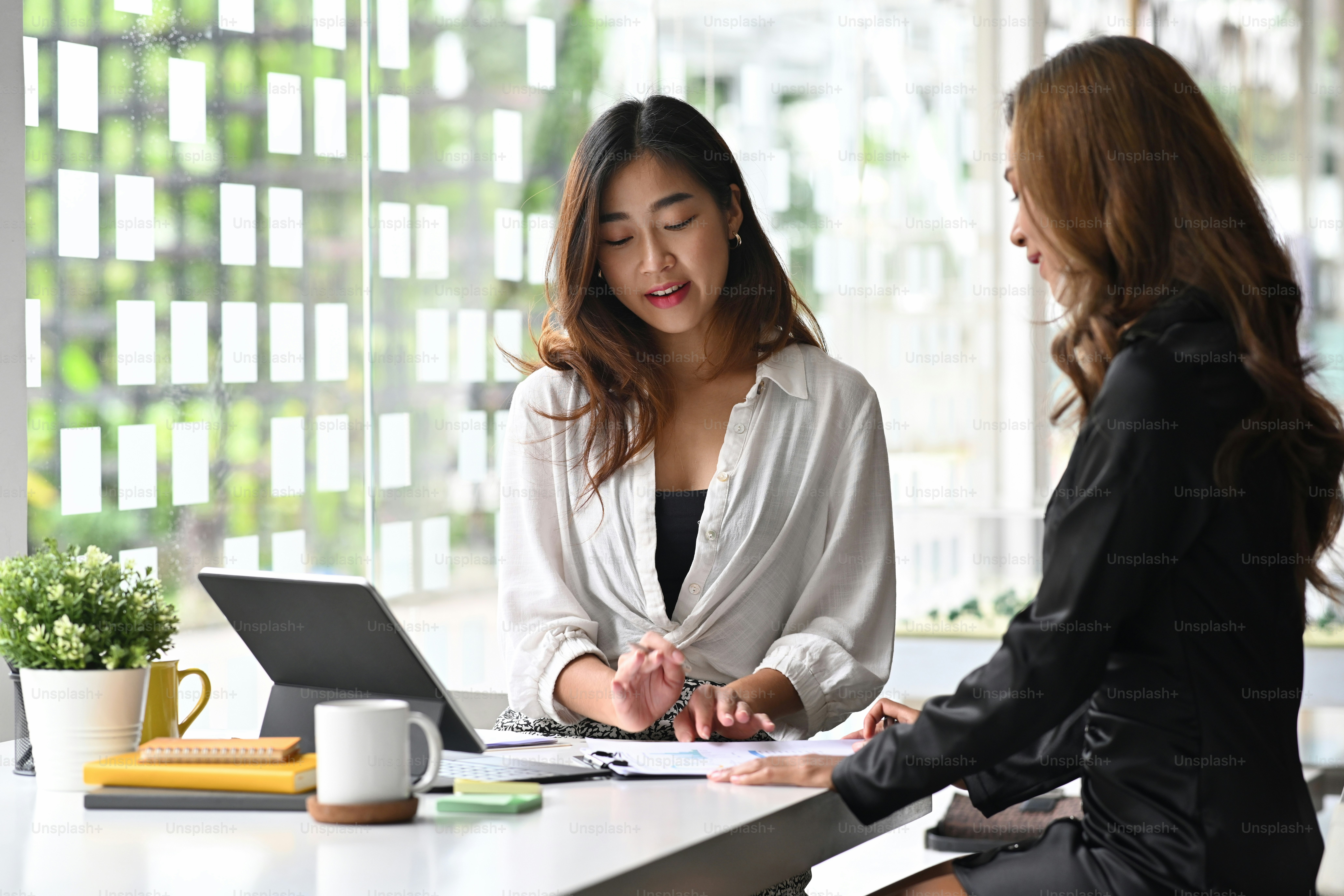 Two businesspeople discussing documents together at office.