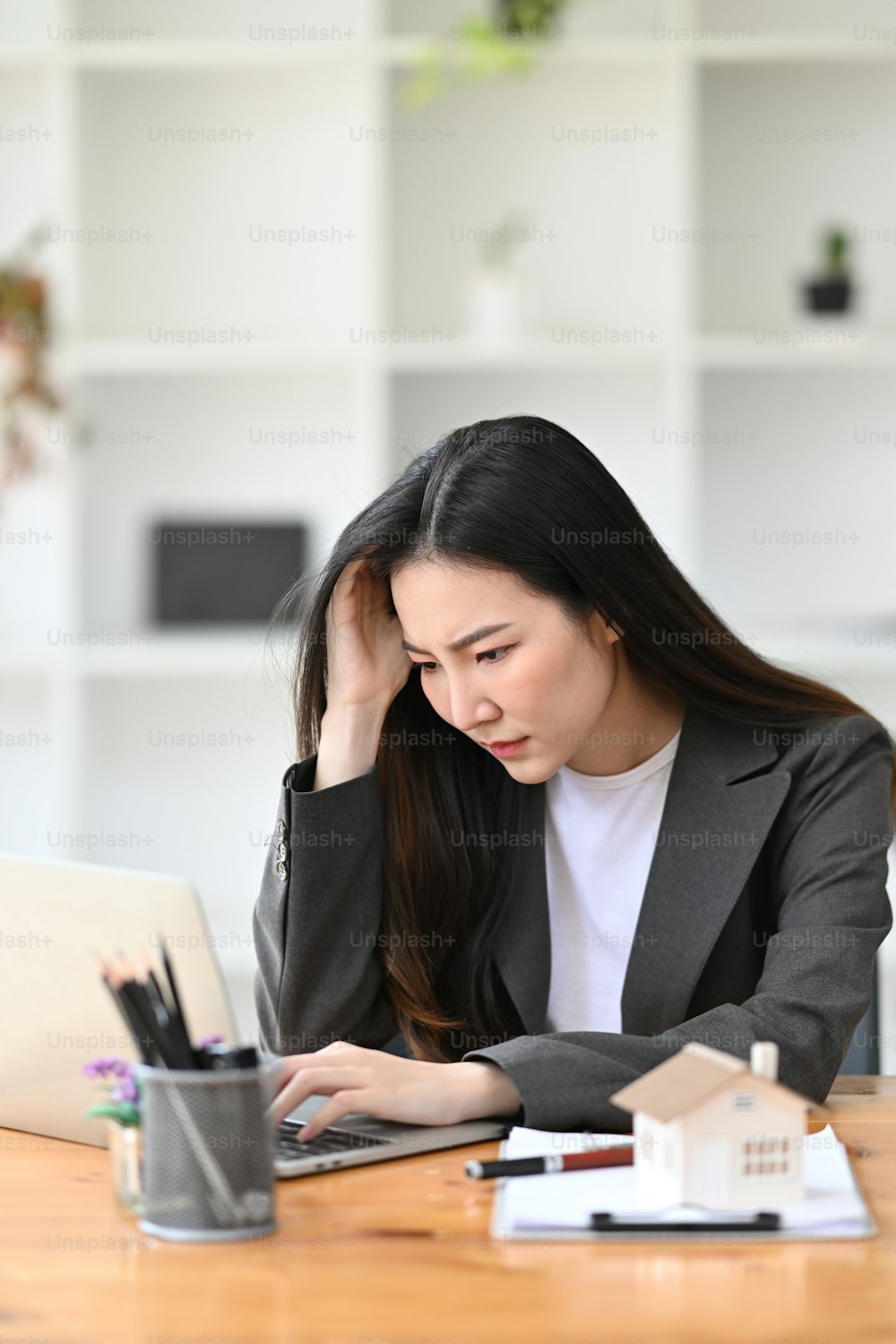 Müde asiatische Geschäftsfrau, die sich von Geschäftsproblemen oder Arbeitsstress frustriert fühlt.